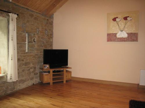 a living room with a flat screen tv on a stone wall at Holiday Home Glenhouse by Interhome in Dernagree