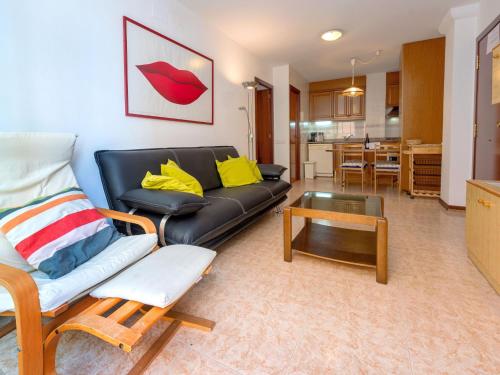 sala de estar con sofá de cuero negro y mesa en Apartment Primer de Maig by Interhome, en Sitges