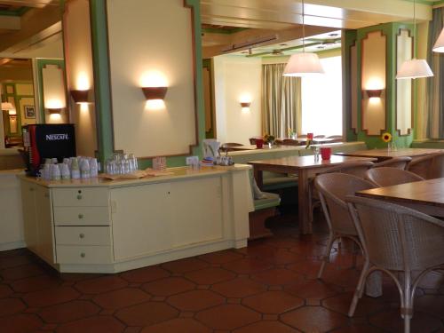 a restaurant with tables and chairs and a mirror at Hotel YOUHEY am Wolfgangsee in Strobl