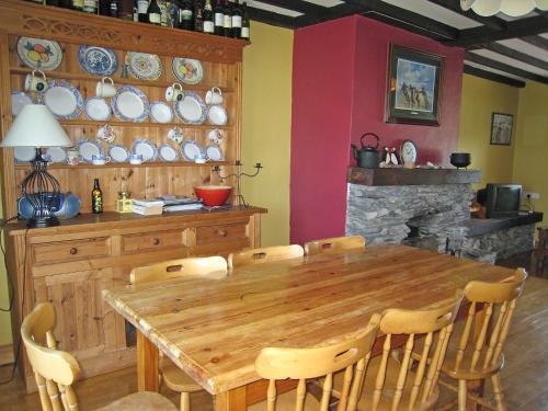 uma sala de jantar com uma mesa de madeira e cadeiras em Holiday Home Seaside Cottages-1 by Interhome em Ilha de Valentia