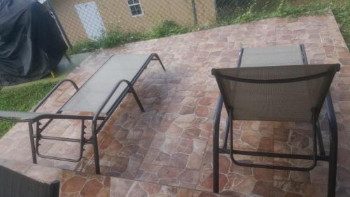 two chairs and a table on a brick patio at Falmouth Oasis in Florence Hall