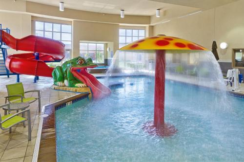 een zwembad met een glijbaan in een gebouw bij ClubHouse Hotel and Suites in Pierre