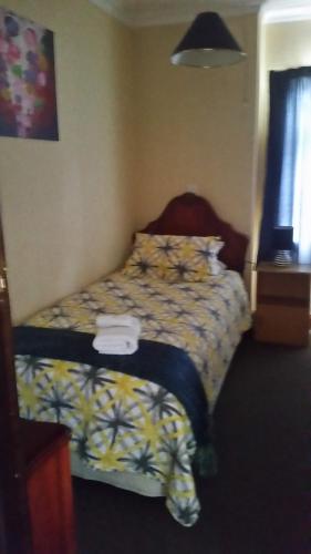 a bedroom with a bed with a comforter on it at Foveaux Hotel in Bluff