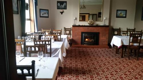 a dining room with tables and a fireplace at Foveaux Hotel in Bluff
