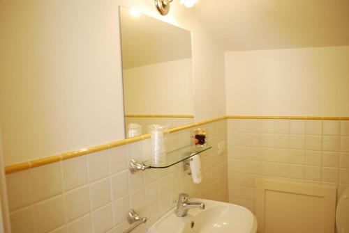 La salle de bains est pourvue d'un lavabo, d'un miroir et de toilettes. dans l'établissement Locanda I Piceni, à Ortezzano