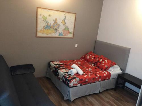 Habitación pequeña con cama con almohadas rojas en Mini Loft Buenavista 106, en Ciudad de México