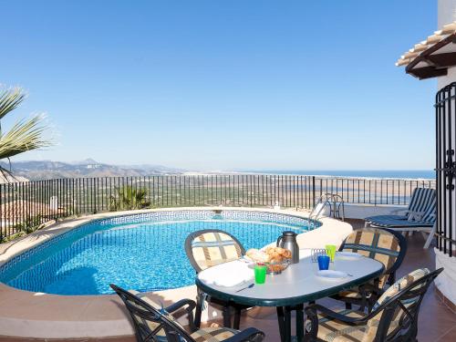 un patio con mesa y sillas junto a una piscina en Villa Stella by Interhome en Monte Pego