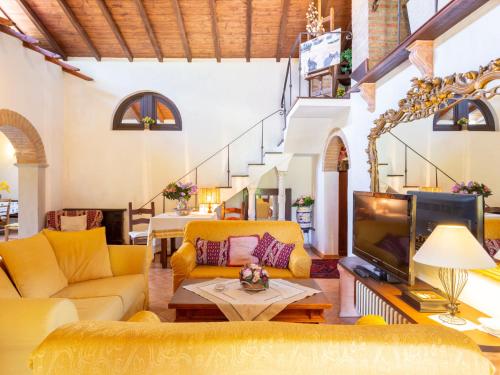 a living room with yellow furniture and a tv at Holiday Home Il Casale by Interhome in Molezzano