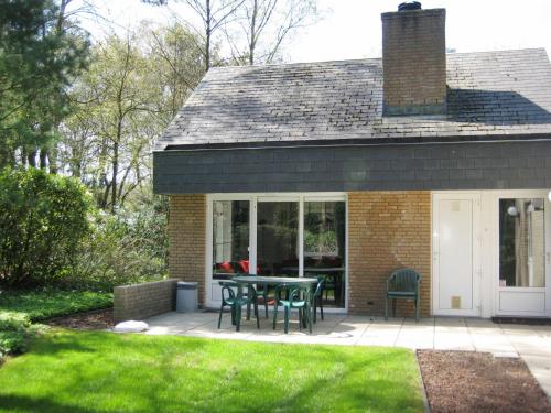 a patio with a table and chairs in front of a house at Holiday Home 6L-5 by Interhome in Lochem