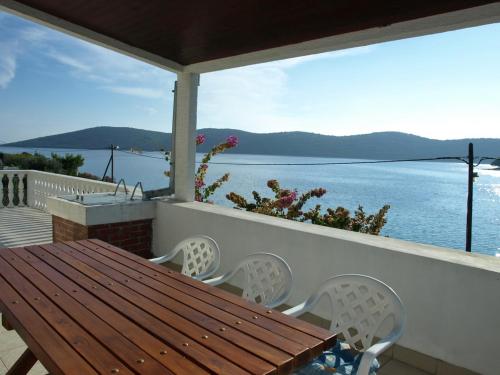 einen Tisch und Stühle auf einem Balkon mit Blick auf das Wasser in der Unterkunft Apartment Agneza by Interhome in Brgulje