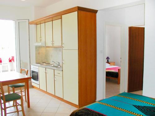 kuchnia z białymi szafkami i kuchnia ze stołem w obiekcie Apartment Zdenko-3 by Interhome w mieście Kali