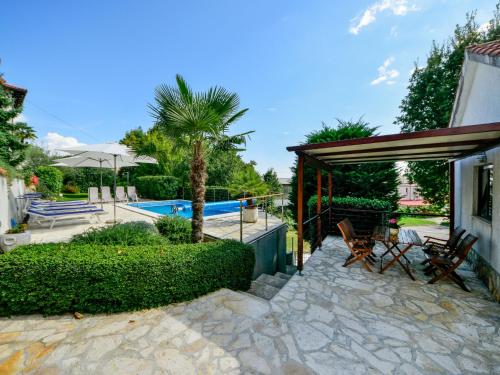 a house with a patio and a swimming pool at Holiday Home Lucija by Interhome in Matulji