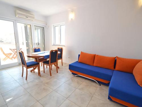 a living room with a blue couch and a table at Apartment Golub-2 by Interhome in Cesarica