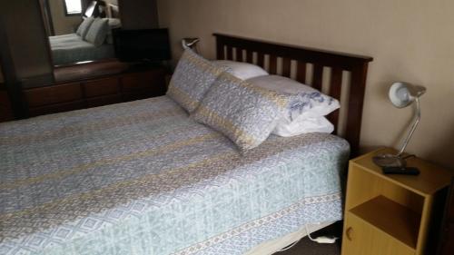 a bedroom with a bed with a pillow and a lamp at Foveaux Hotel in Bluff
