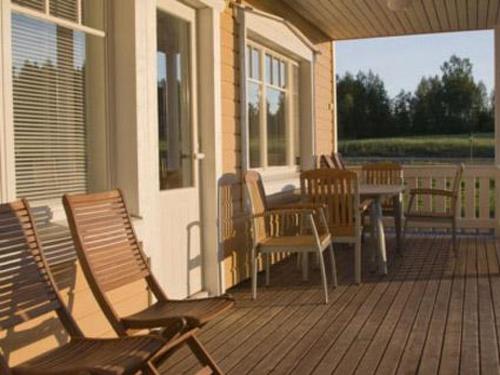a porch with rocking chairs and a table on a house at Holiday Home Mielikki by Interhome in Kurkimaki