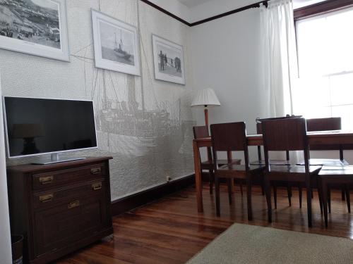 a living room with a dining room table and a television at Casa da American Cable Company in Horta