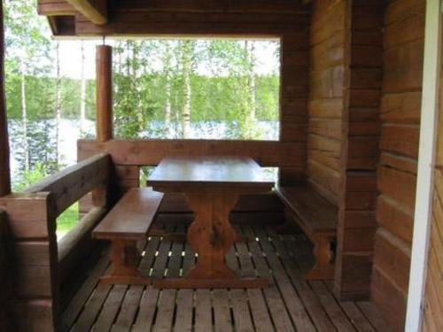 a wooden porch with a bench in a cabin at Holiday Home Pellervo by Interhome in Kurkimaki