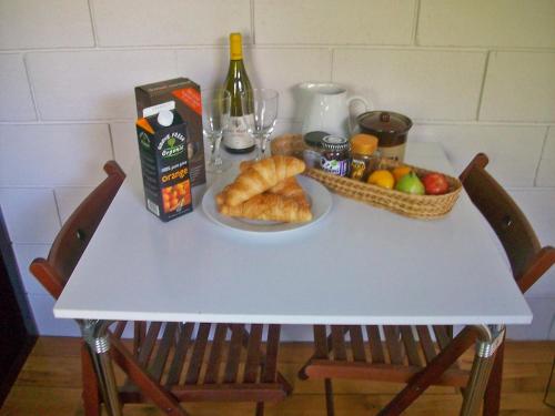 een tafel met een bord brood en een fruitmand bij Apartment Holly Lodge Coach House by Interhome in Londen