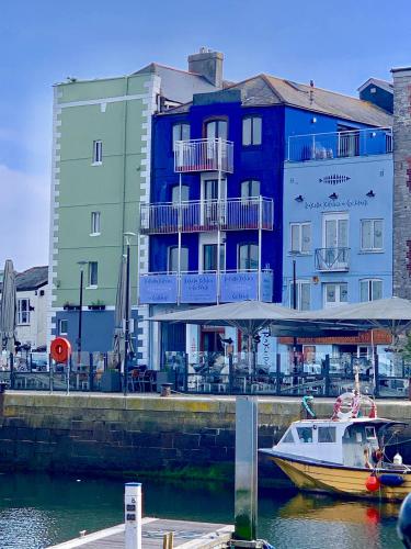 a boat in the water in front of a building at The Barbican Apartments in Plymouth