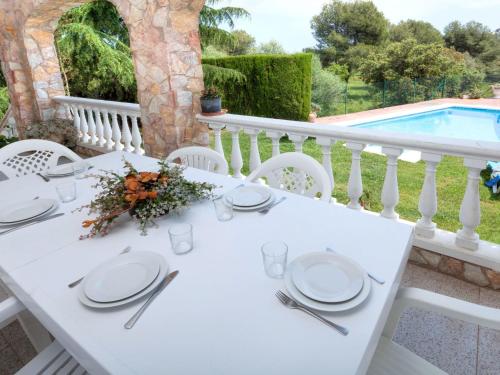 a white table with plates and utensils on a balcony at Holiday Home Mas Vila by Interhome in Sant Antoni de Calonge