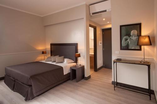 a hotel room with a bed, desk, and a television at Nazionale 51 Group in Rome