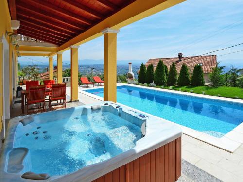 a hot tub on a patio next to a swimming pool at Holiday Home Villa Olea by Interhome in Opatija