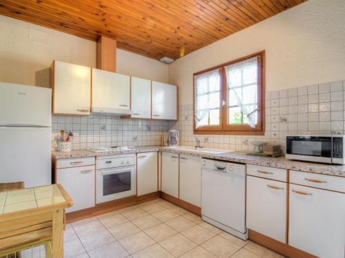 kuchnia z białymi urządzeniami i drewnianym sufitem w obiekcie Holiday Home Les Vignes Océanes by Interhome w mieście Capbreton