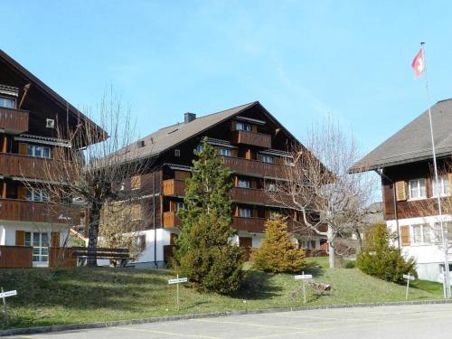 duży budynek apartamentowy z flagą przed nim w obiekcie Apartment Suzanne Nr- 20 by Interhome w mieście Gstaad