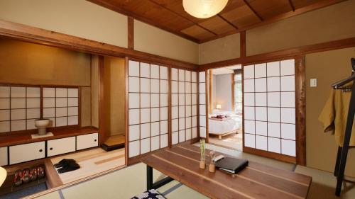 奈良市にあるNIPPONIA HOTEL 奈良 ならまちの白い壁の客室で、テーブルと窓が備わります。