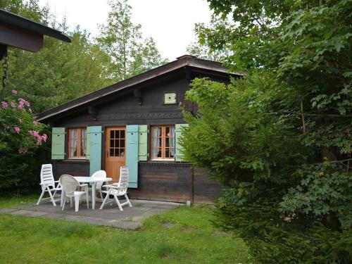 ein kleines Haus mit einem Tisch und Stühlen im Hof in der Unterkunft Apartment Ismene- Chalet by Interhome in Gstaad