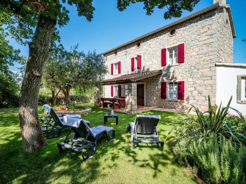 an old stone house with chairs and a tree at Holiday Home Tommy by Interhome in Gedići