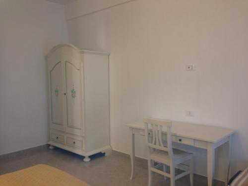 a room with a desk and a cabinet and a table at Affittacamere Villa Brazzano in Scalea
