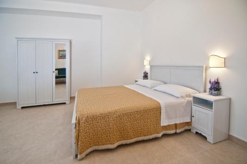 a bedroom with a large bed and a dresser at Home Holiday Salento La Scisa in Alessano
