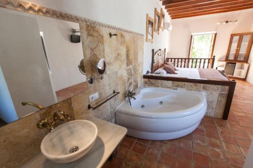 a bathroom with a large tub and a sink at Agroturismo Can Pere Sord in Sant Joan de Labritja