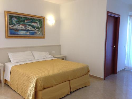 スカレアにあるAffittacamere Villa Brazzanoのベッドルーム1室(ベッド1台付)が備わります。壁に絵が飾られています。