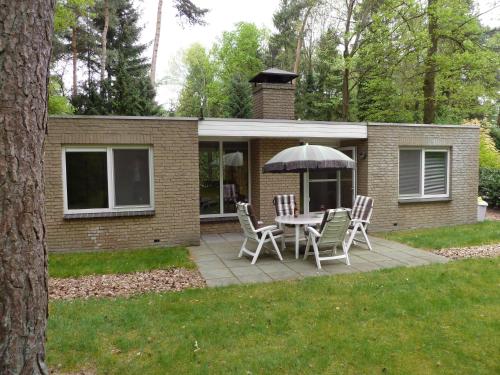 a patio with a table and chairs and an umbrella at Holiday Home 2-1 by Interhome in Lochem