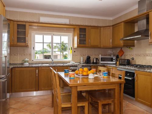 a kitchen with a wooden table with oranges on it at Villa Das Amendoeiras by Interhome in Estevais