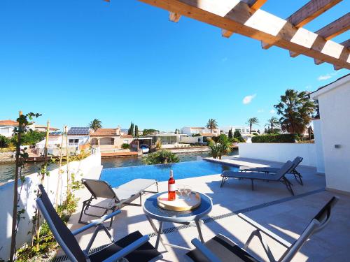 a patio with chairs and a table and a pool at Holiday Home Alberes by Interhome in Empuriabrava