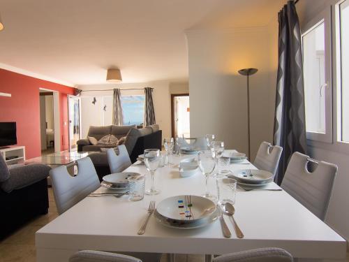 ein Esszimmer mit einem Tisch mit Tellern und Weingläsern in der Unterkunft Holiday Home Pelzer by Interhome in Conil