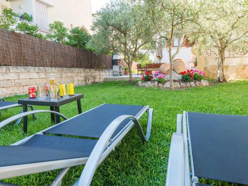 two picnic tables and chairs in a yard at Holiday Home Can Roses by Interhome in Playa de Muro