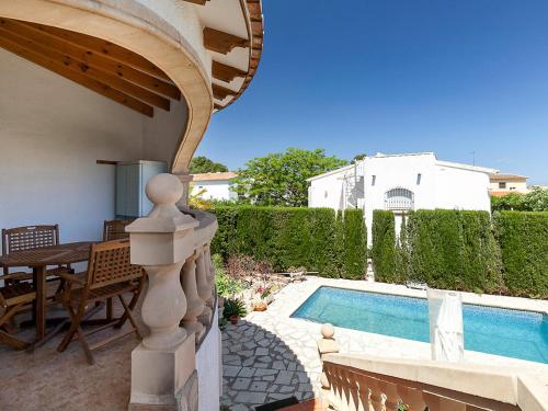 un patio trasero con piscina, mesa y sillas en Villa Tulipanes by Interhome, en Denia