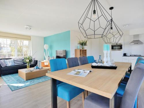 comedor y sala de estar con mesa y sillas azules en Holiday Home de Witte Raaf-2 by Interhome en Noordwijk