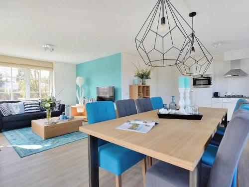 ノールトウェイクにあるHoliday Home de Witte Raaf-1 by Interhomeのダイニングルーム、リビングルーム(テーブル、青い椅子付)