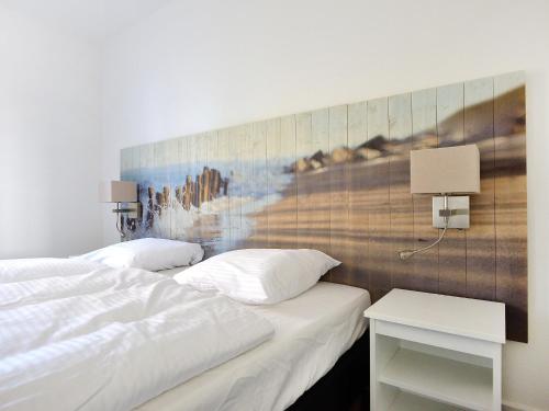 een slaapkamer met 2 bedden en een schilderij aan de muur bij Holiday Home de Witte Raaf-2 by Interhome in Noordwijk