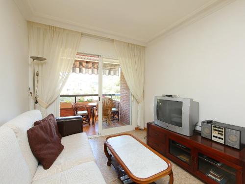 sala de estar con sofá blanco y TV en Apartment Rambla de Tossa by Interhome, en Tossa de Mar