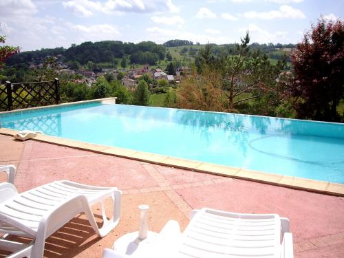 a swimming pool with two lawn chairs next to it at Holiday Home Fromental by Interhome in Bagnac