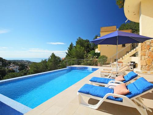 - une piscine avec des chaises longues et un parasol dans l'établissement Holiday Home Negrita by Interhome, à Benissa