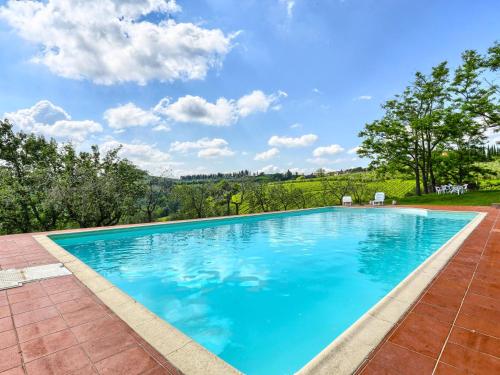 a large swimming pool with blue water at Apartment Chiantishire retreat-1 by Interhome in Barberino di Val dʼElsa