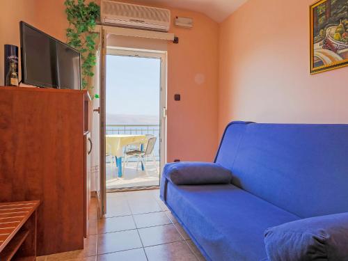 salon z niebieską kanapą i telewizorem w obiekcie Apartment Delfin-10 by Interhome w mieście Cesarica