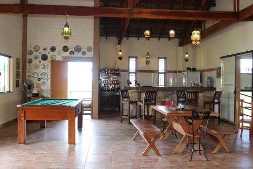 a room with tables and chairs and a pool table at Pousada Sítio Pedras de Minas in Monte Sião